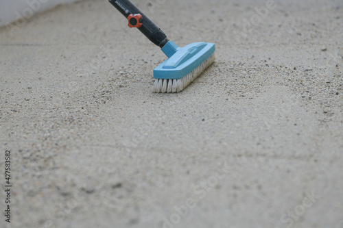Garden broom. Tools for landscaping. Cleaning the pavers from sand after creating a space in the backyard.