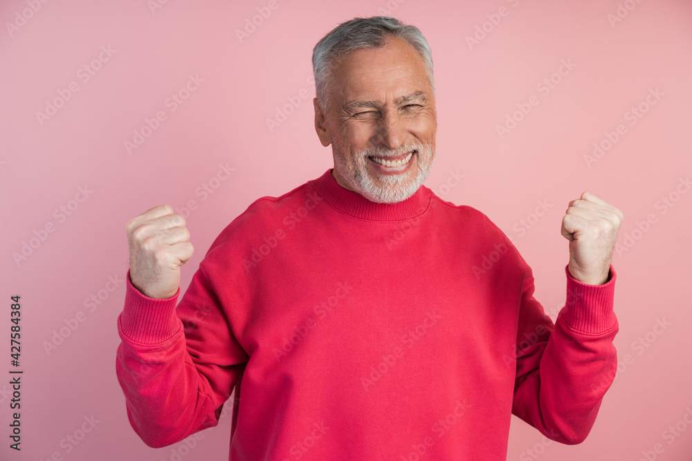 Joyful, senior man posing on a pink background, he loves the gesture of victory. The man is very happy, he closed his eyes and rejoices in the victory, clenched his fists. Joyful, senior man posing on a pink background, he loves the gesture of victory. The man is very happy, he closed his eyes and rejoices in the victory, clenched his fists.