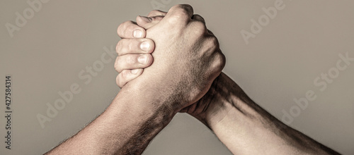 Arms wrestling. Closep up. Friendly handshake, friends greeting, teamwork, friendship. Handshake, arms, friendship. Hand rivalry vs challenge strength comparison. Man hand. Two men arm wrestling photo