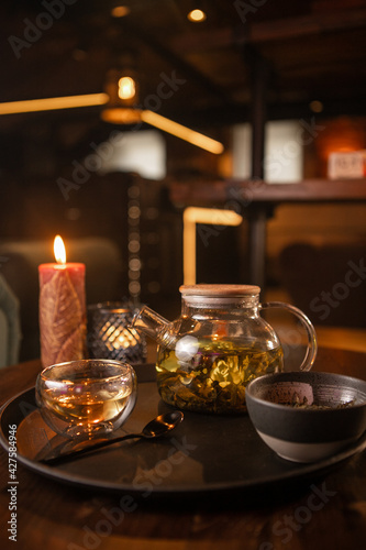 Tea brewing process  tea ceremony  freshly brewed green tea cup  warm soft light  dark background.