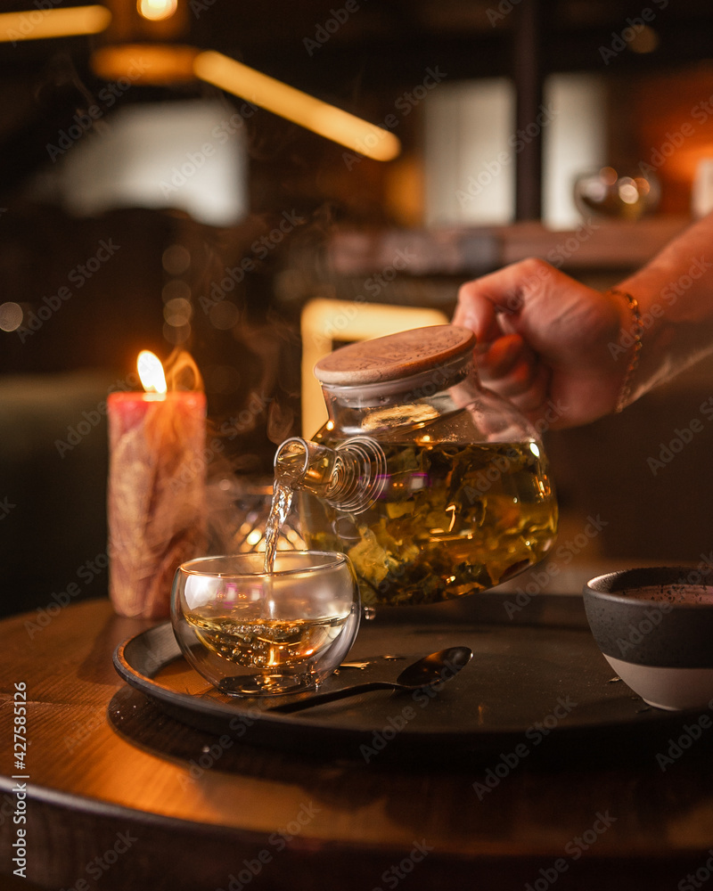 Tea brewing process, tea ceremony, freshly brewed green tea cup, warm soft light, dark background. Tea brewing process, tea ceremony, freshly brewed green tea cup, warm soft light, dark background.