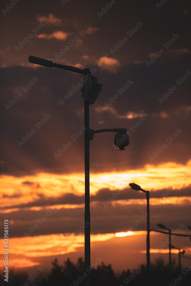 Surveillance camera silhouette. Dramatic sunset sky in background. Security technology. Surveillance camera silhouette. Dramatic sunset sky in background. Security technology.