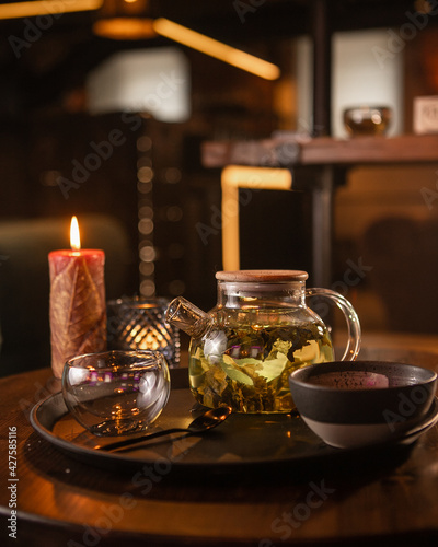Tea brewing process, tea ceremony, freshly brewed green tea cup, warm soft light, dark background.