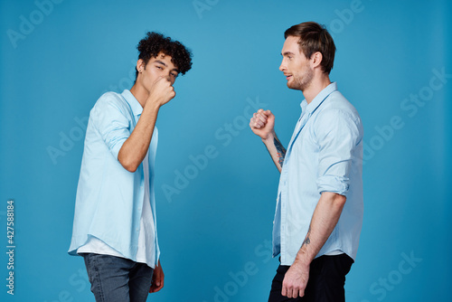 curly-haired guy in a shirt greets his friend on a blue background