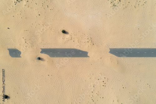 Canvas Print Birds eye view of a sand covered empty road in the Dubai desert