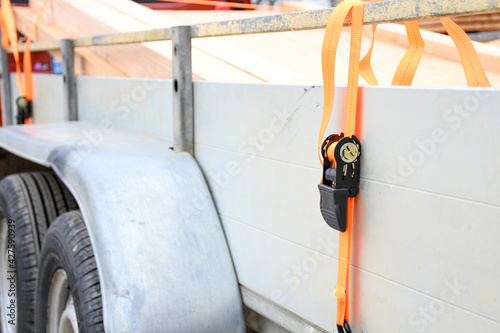Foto Trailer strop or strap in orange nylon and metal, object helping for holding stuff , storage and transport for safty and security