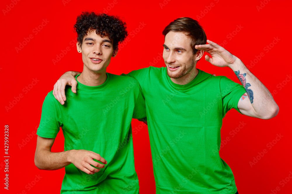 Two man green t-shirts embrace emotions friendship red background Two man green t-shirts embrace emotions friendship red background