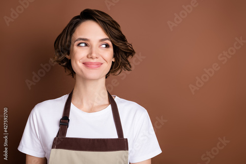 Photo of charming satisfied person smile look interested empty space isolated on brown color background photo