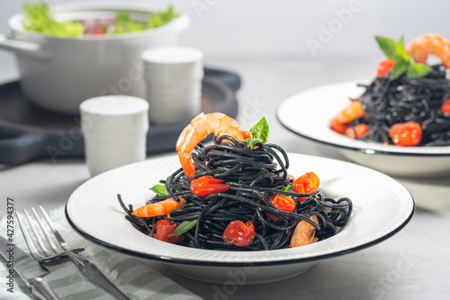 Vászonkép Dinner with black seafood pasta. Two portions.