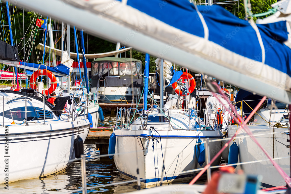 Yachts moored in a harbor. Sailboats in the dock. Summer vacations, cruise, recreation, sport, regatta, leisure activity, service, tourism Yachts moored in a harbor. Sailboats in the dock. Summer vacations, cruise, recreation, sport, regatta, leisure activity, service, tourism