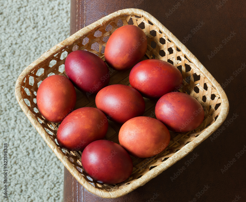 Brown dyed Easter eggs in a square wicker basket. On a white-brown background. View from above. Registration for the holiday. Brown dyed Easter eggs in a square wicker basket. On a white-brown background. View from above. Registration for the holiday.