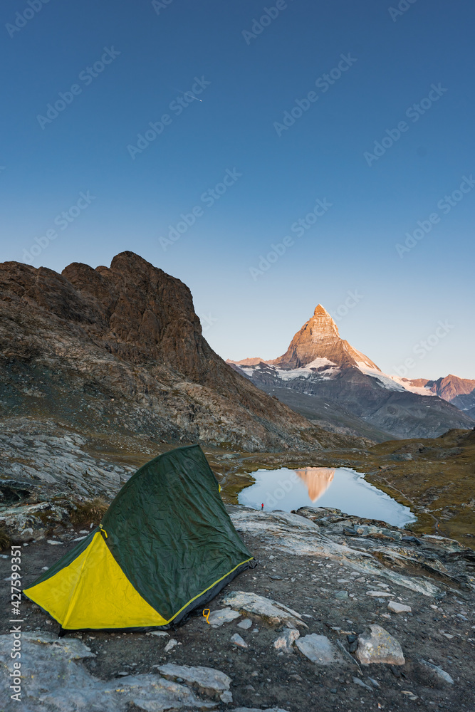 Camping in the mountain, Backpacking in Dolomites, Switzerland view to Lake and mountain. Striking panoramic landscape view of a tent.
