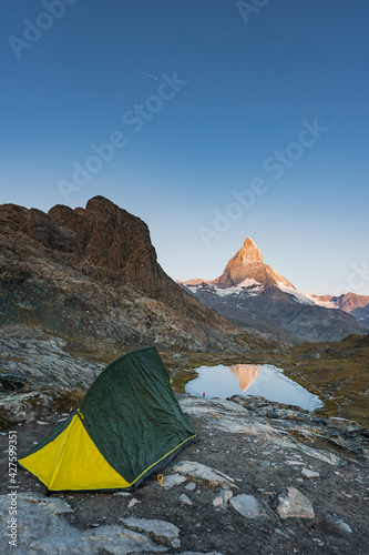 Camping in the mountain, Backpacking in Dolomites, Switzerland view to Lake and mountain. Striking panoramic landscape view of a tent. 