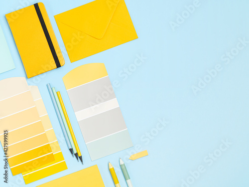 Simple, bright and colourful artists, designers workplace background with place for text. Colour samples palette, notebook, pens, pencils frame for people of creative professions and students.