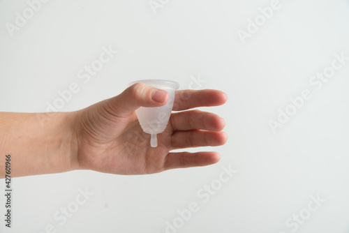 hand is holding menstrual cup on white background