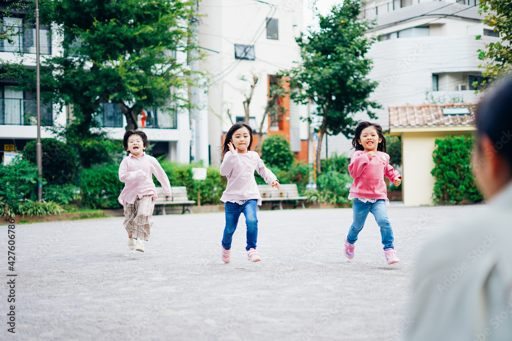 Obraz premium かけっこをする子どもたちとお母さん