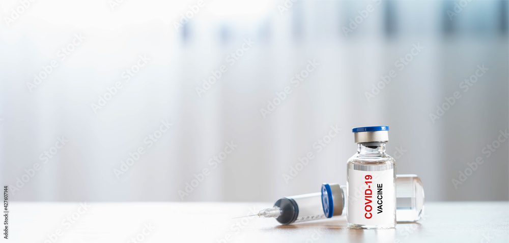 Healthcare and Medical concept. Close up bottle vial of covid-19 coronavirus vaccine treatment and syringe on office desk at research medical laboratory. copy space. doctor or scientist tools.