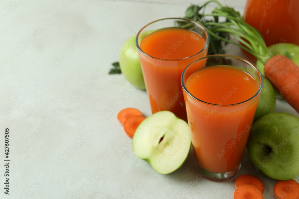 Glasses with juice and ingredients on white textured background Glasses with juice and ingredients on white textured background