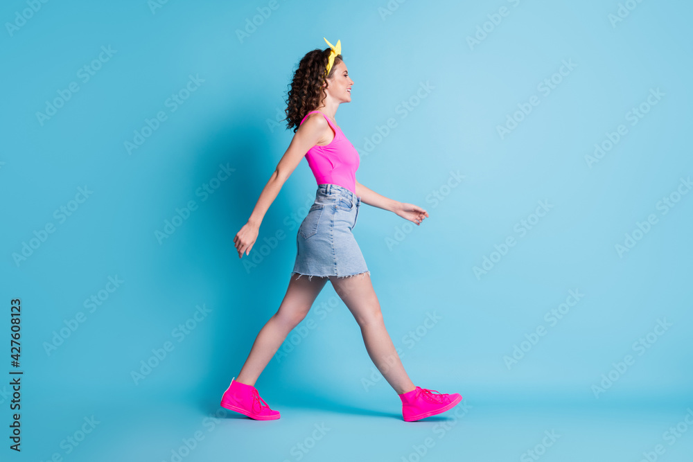 Full size profile side photo of happy woman walk empty space wear casual summer outfit isolated on blue color background