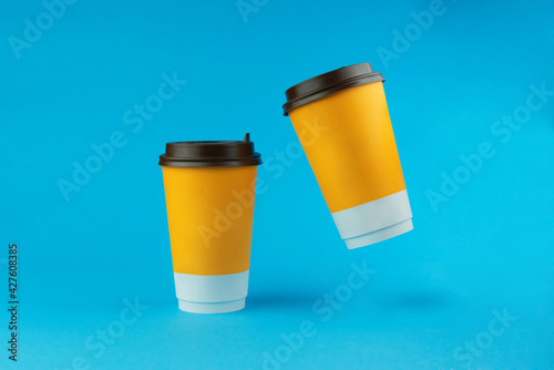 Two paper coffee cups on a blue background