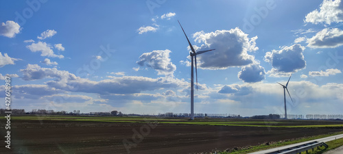 windmills in a green field against a blue sky