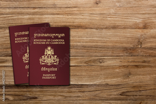 Cambodia passport on a wooden background, lay flat. Space for text