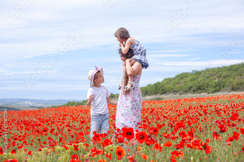 Happy family resting together. mother and kids have fun in the field outdoor in countryside  breathes the air and enjoi the freedom