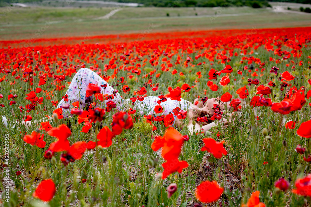 Obraz premium Happy woman in sundress walking in the field with wild flowers and make the bouquet