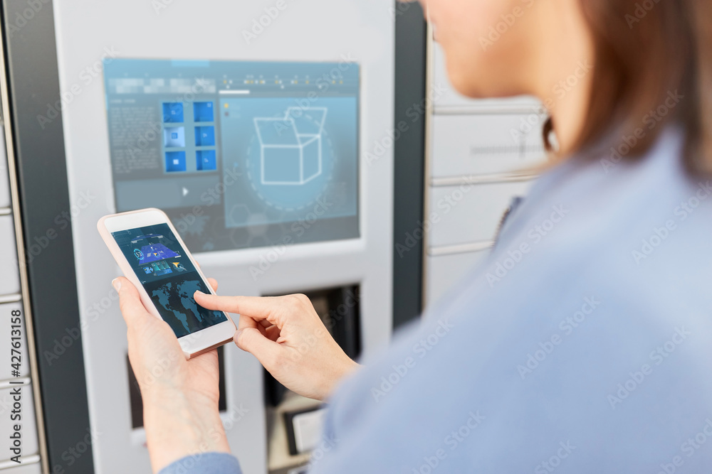 mail delivery, technology and post service concept - close up of woman with smartphone choosing operation on outdoor automated parcel machine's touch screen mail delivery, technology and post service concept - close up of woman with smartphone choosing operation on outdoor automated parcel machine's touch screen