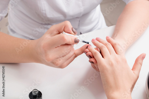 Close-up of female hands during a manicure procedure in the salon.