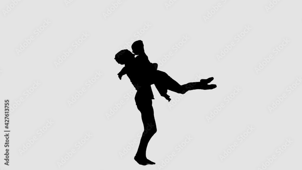 Silhouette professional ballet pair practicing moves on dark stage. Gracefulness and tenderness in every movement. Silhouette professional ballet pair practicing moves on dark stage. Gracefulness and tenderness in every movement.
