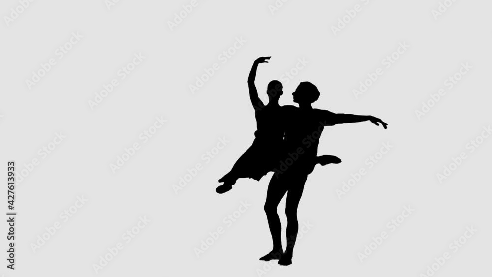 Silhouette professional ballet pair practicing moves on dark stage. Gracefulness and tenderness in every movement. Silhouette professional ballet pair practicing moves on dark stage. Gracefulness and tenderness in every movement.