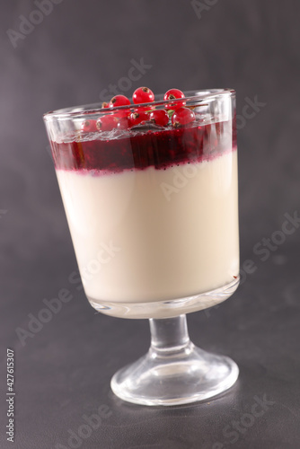 glass of panna cotta with red currant