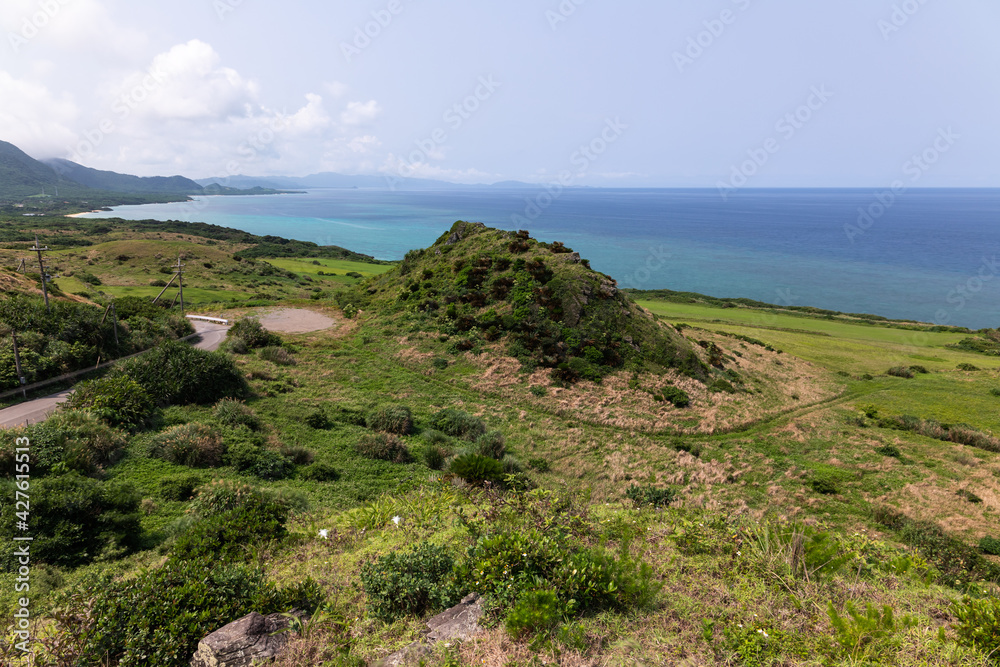石垣島最北端の平久保崎で新緑の丘陵地からコバルトブルーの海を眺める