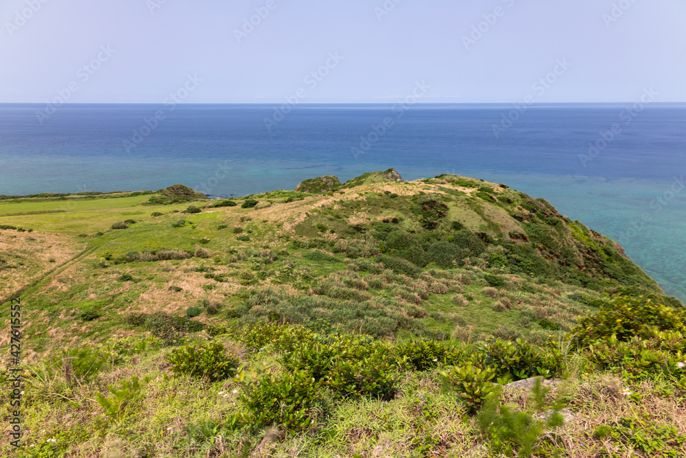 石垣島最北端の平久保崎で新緑の丘陵地からコバルトブルーの海を眺める