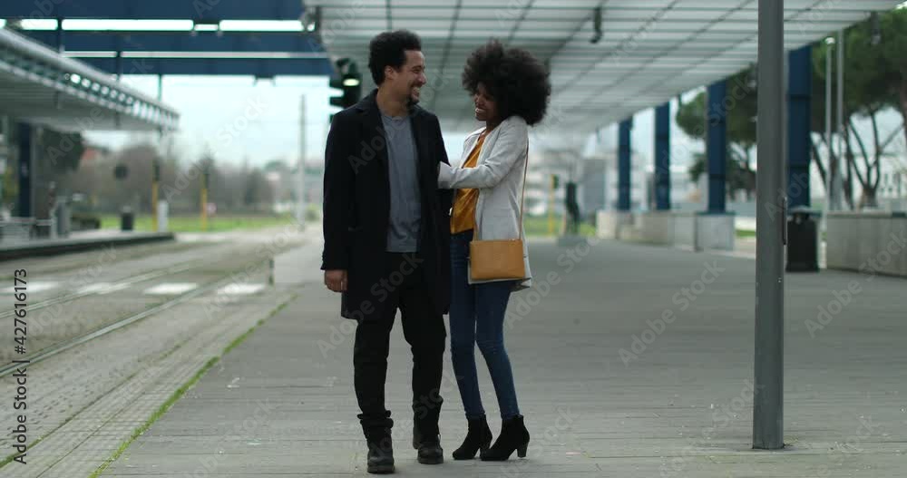 Romantic couple walking arm in arm at train station Romantic couple walking arm in arm at train station