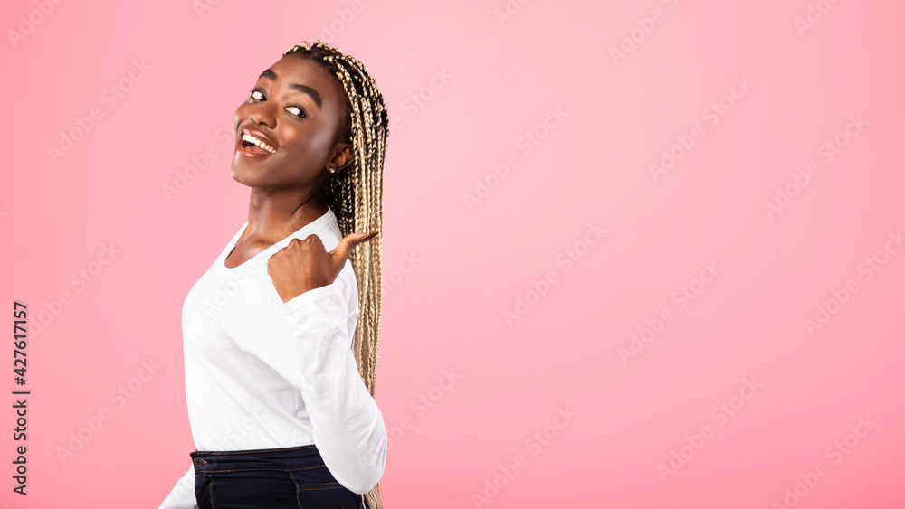 Excited black woman pointing back at copy space Excited black woman pointing back at copy space