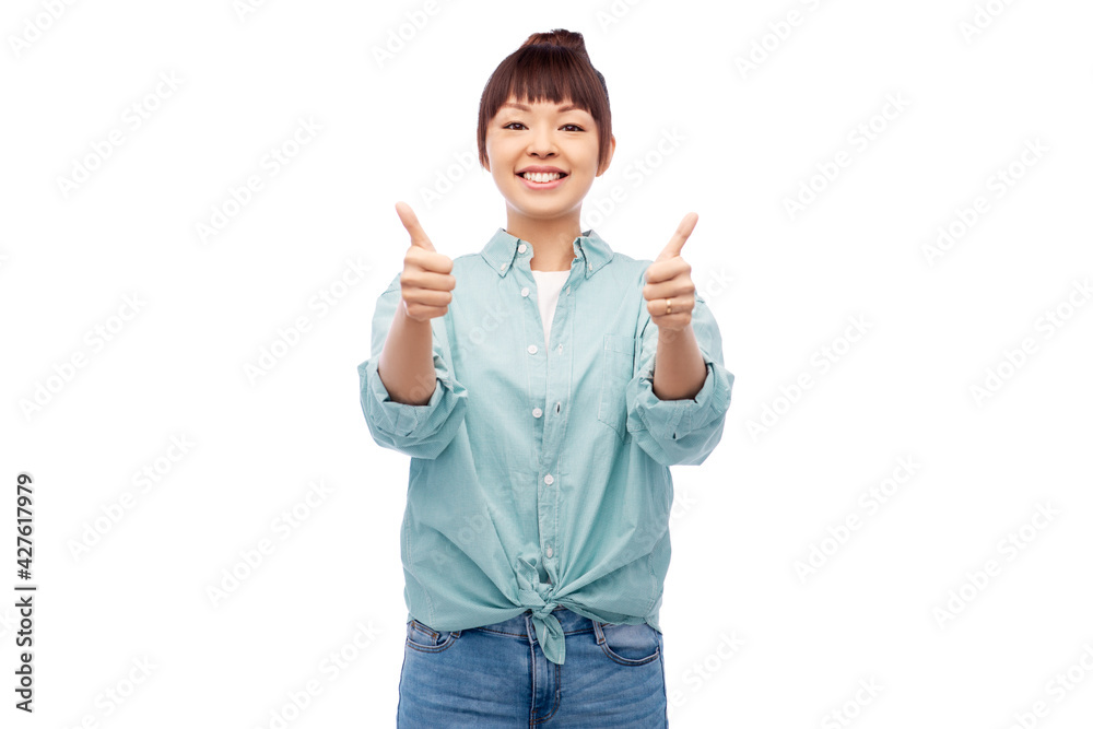 people, ethnicity and gesture concept - happy asian young woman in cotton shirt showing thumbs up over white background people, ethnicity and gesture concept - happy asian young woman in cotton shirt showing thumbs up over white background