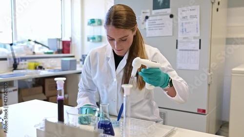 Wallpaper Mural Laboratory assistant pipetting blue liquid Torontodigital.ca