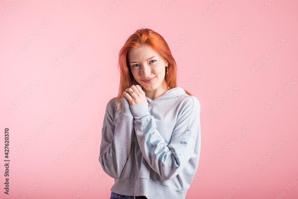 Portrait of a happy redhead girl in the studio on a pink background Portrait of a happy redhead girl in the studio on a pink background