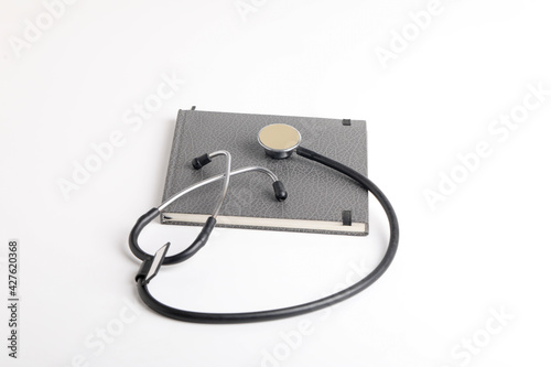 Black stethoscope lying on the diary, medicine.