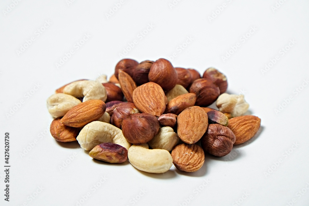 Pile of mixed nuts and dried berries isolated on white background. Healthy high-calorie vegan food concept. Close up, copy space, top view, flat lay. Pile of mixed nuts and dried berries isolated on white background. Healthy high-calorie vegan food concept. Close up, copy space, top view, flat lay.