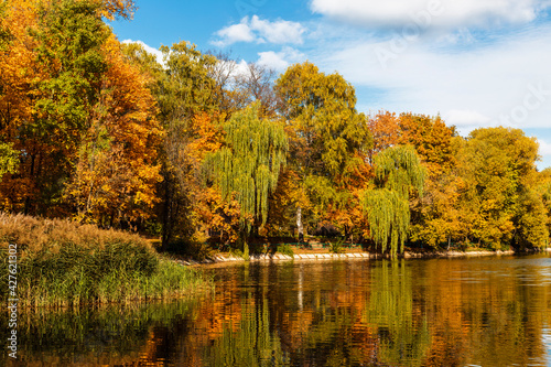 Picturesque view of the autumn forest, bright, colorful trees and their reflection in the pond