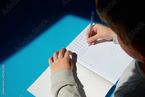 child writes top view. child practices writing at home top view. homework. side view. selective focus 