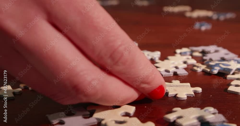 Young Woman Solving A Jigsaw Puzzle Young Woman Solving A Jigsaw Puzzle