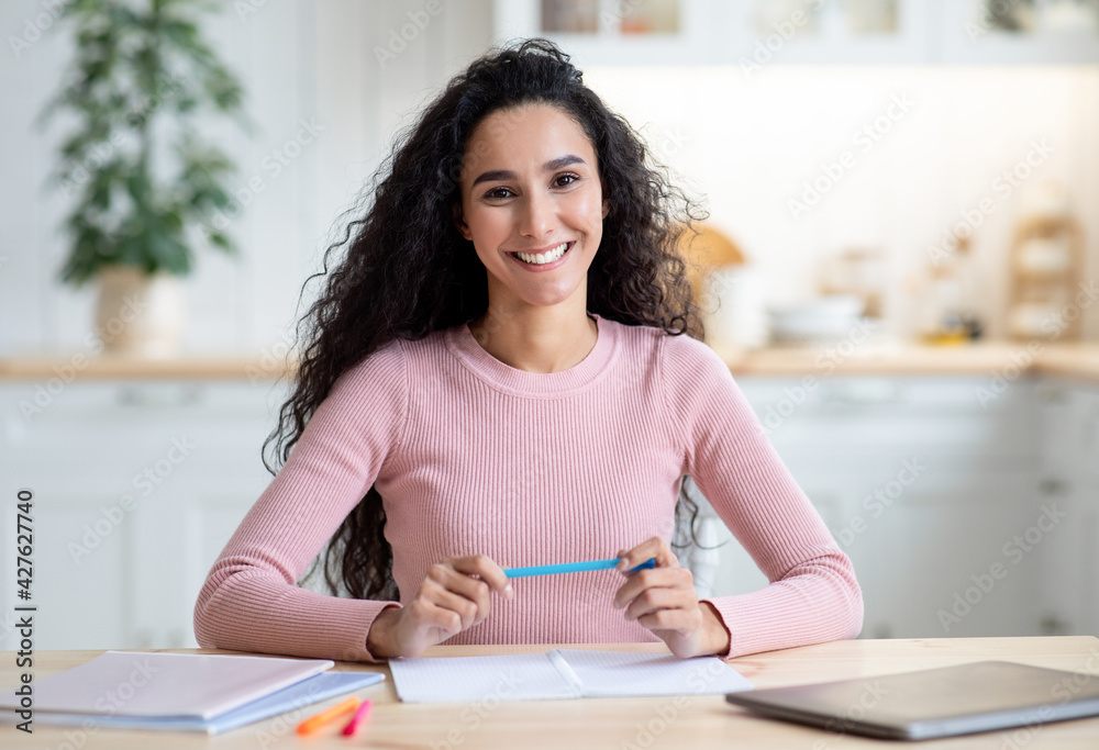 Remote Professions. Young Female Tutor Sitting At Table And Smiling At Camera Remote Professions. Young Female Tutor Sitting At Table And Smiling At Camera
