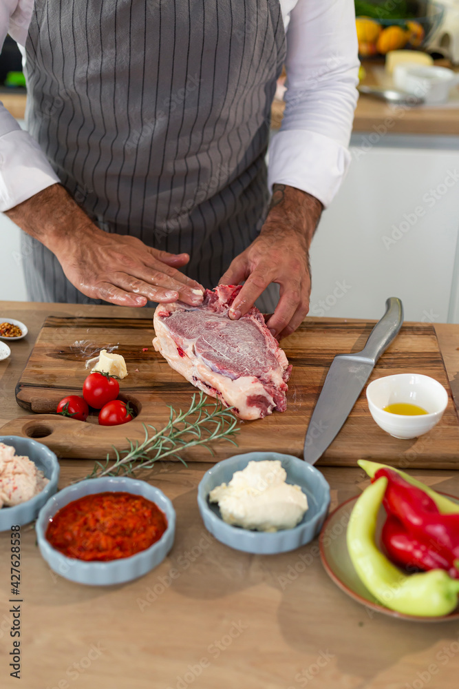 A close-up of a chef rubbing butter into a piece of meat
