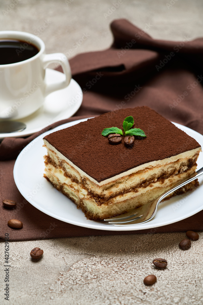 Portion of Traditional Italian Tiramisu dessert and savoiardi cookies on grey concrete background Portion of Traditional Italian Tiramisu dessert and savoiardi cookies on grey concrete background