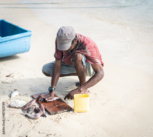 Candid black fisherman on the coast ocean