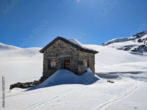 ski tour in austria near the border to switzerland. old customs house on the plasseggen pass. Wonderful winter landscape © SimonMichael